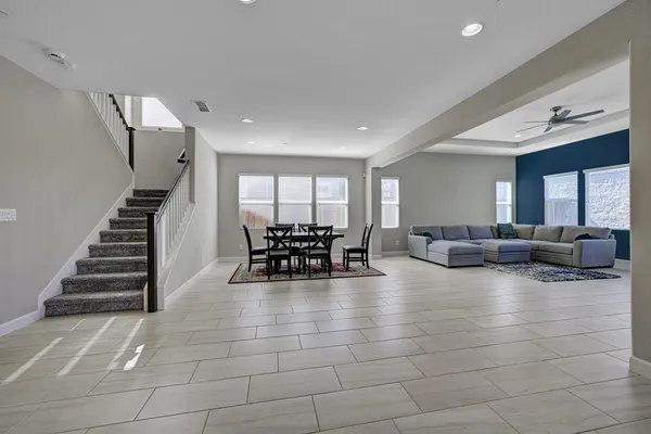 a living room with furniture and white walls next to a window