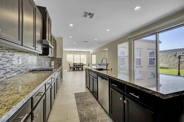 a large kitchen with stainless steel appliances granite countertop counter space a sink and a refrigerator