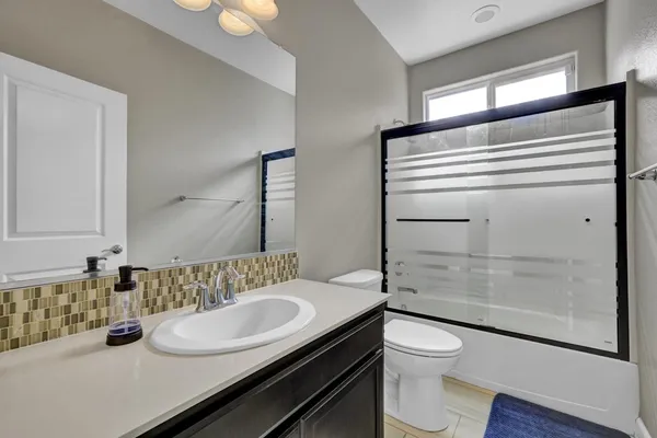a bathroom with a granite countertop sink toilet and shower
