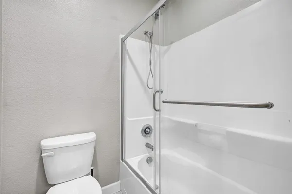 a bathroom with a toilet and a shower
