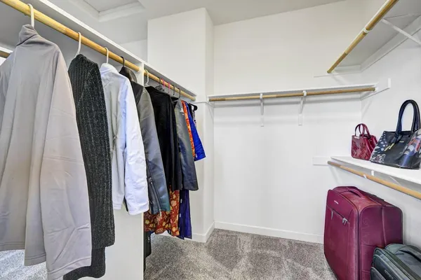 a view of walk in closet with clothes and shoes
