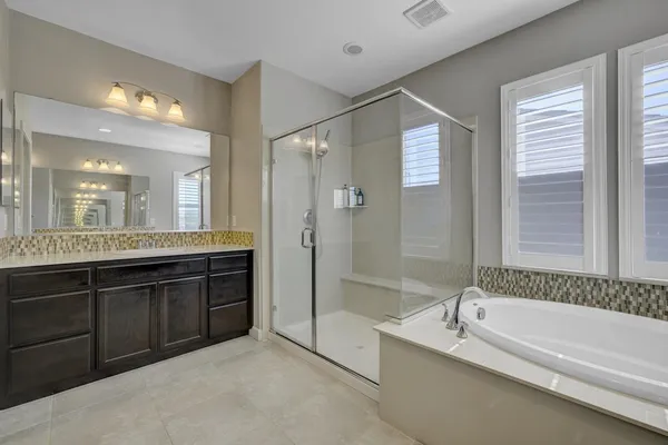 a spacious bathroom with a bathtub shower and sink