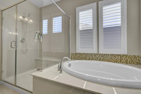 a white bath tub sitting next to a shower