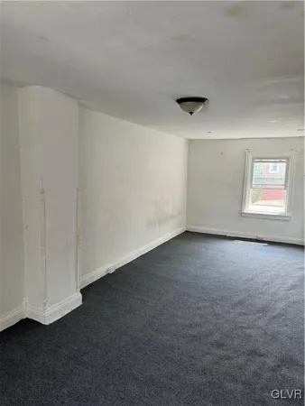 an empty room with a chair and a window