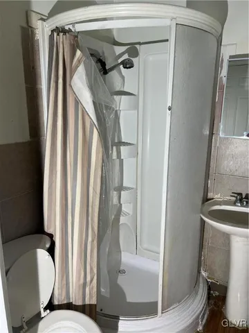 a bathroom with a toilet and a shower