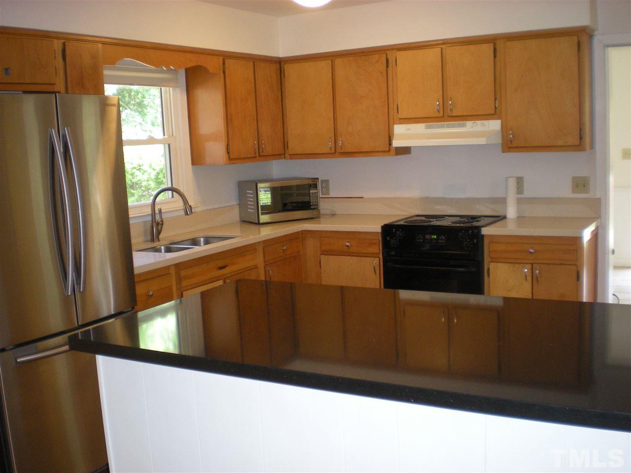 4108 Rockingham Drive Raleigh, NC 27609 - Photo 4 of 13 a kitchen with stainless steel appliances granite countertop a refrigerator a stove a sink and a microwave