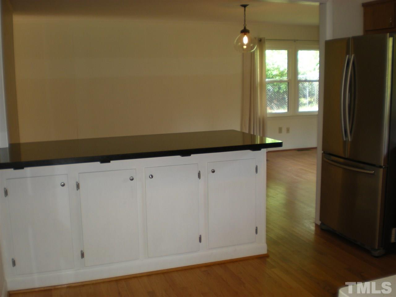 4108 Rockingham Drive Raleigh, NC 27609 - Photo 5 of 13 a view of an empty room with wooden floor and a window