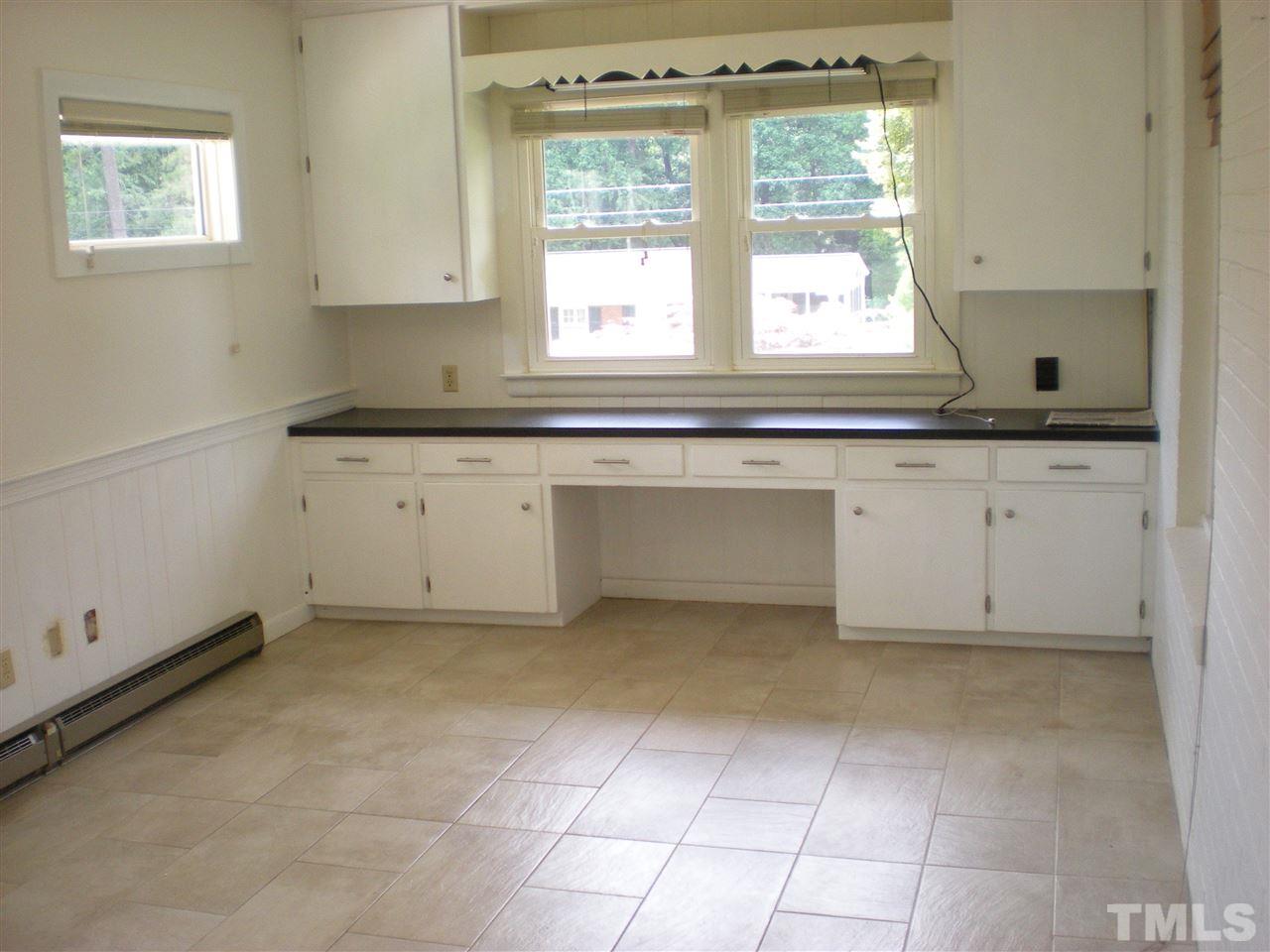 4108 Rockingham Drive Raleigh, NC 27609 - Photo 6 of 13 a kitchen with granite countertop white cabinets and a window