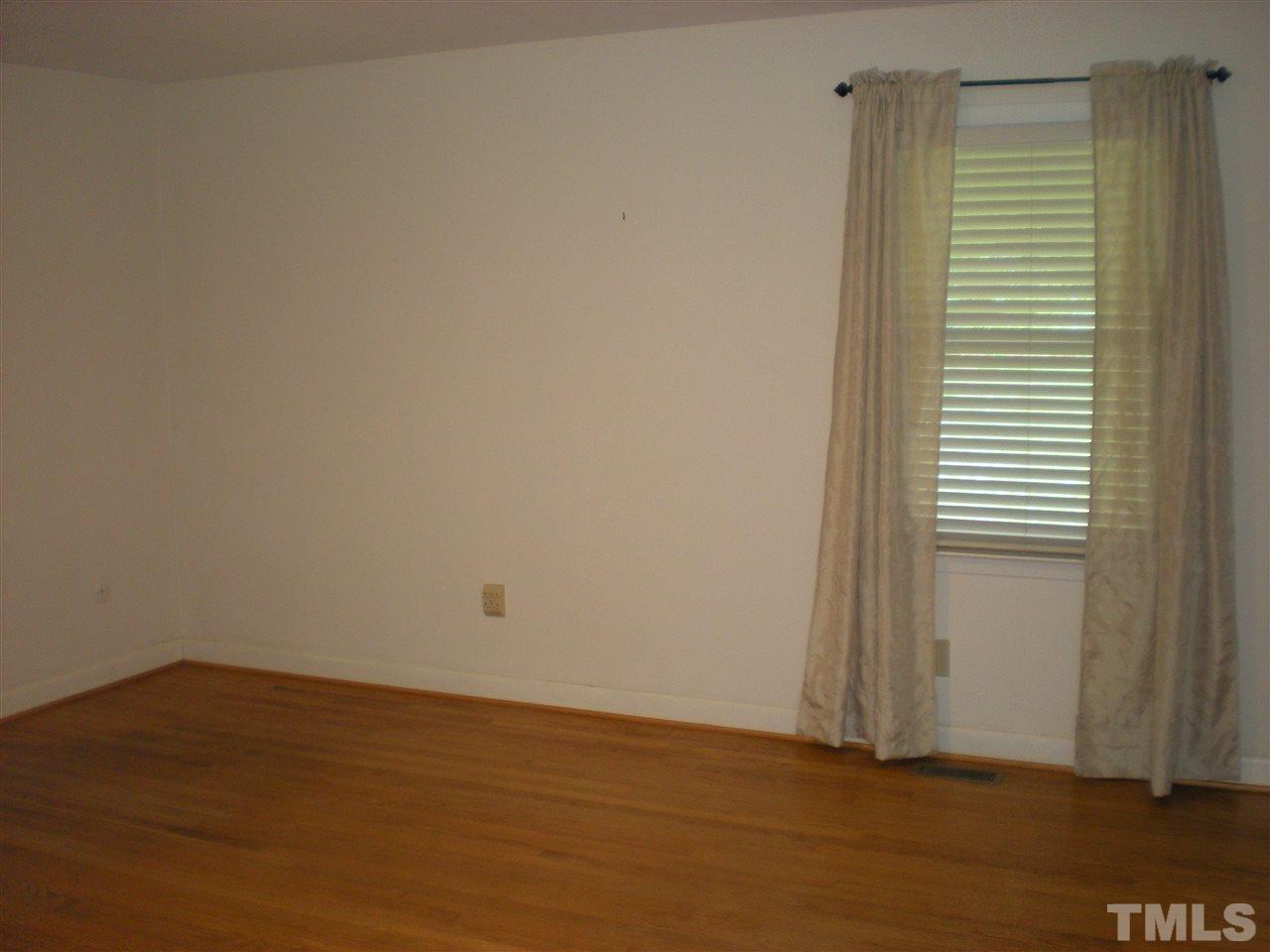 4108 Rockingham Drive Raleigh, NC 27609 - Photo 7 of 13 a view of an empty room with wooden floor and a window