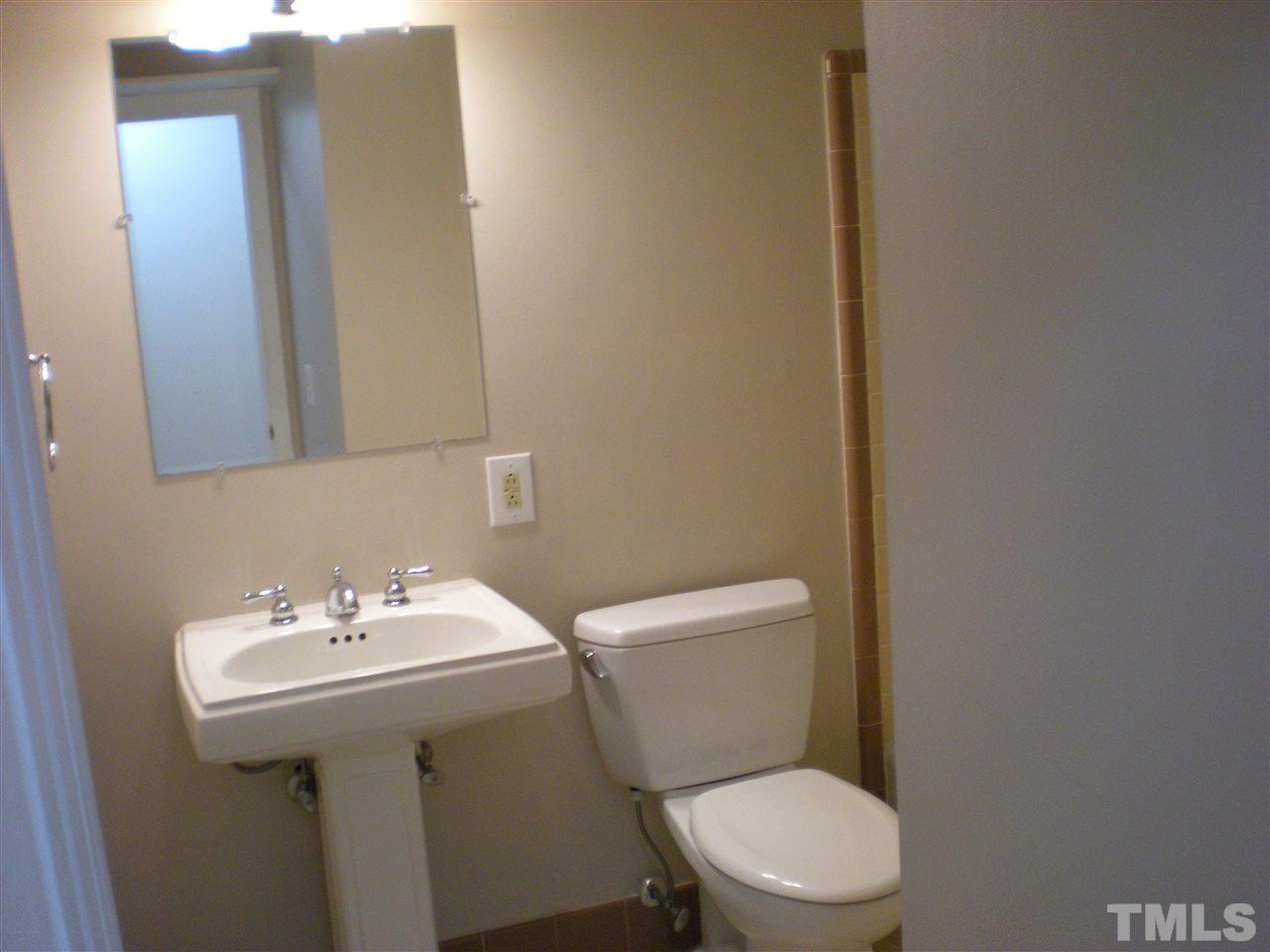 4108 Rockingham Drive Raleigh, NC 27609 - Photo 9 of 13 a white toilet sitting next to a bathroom sink