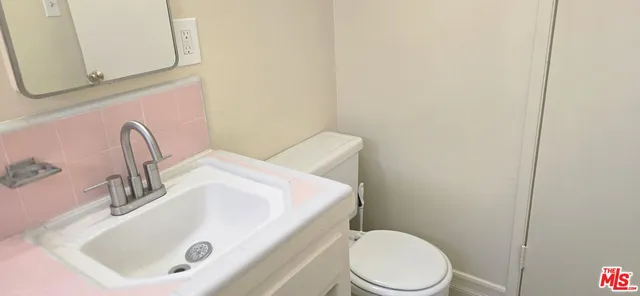 a bathroom with a sink a toilet and mirror