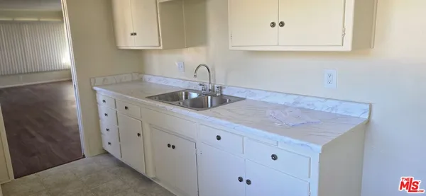 a kitchen with white cabinets a sink and dishwasher
