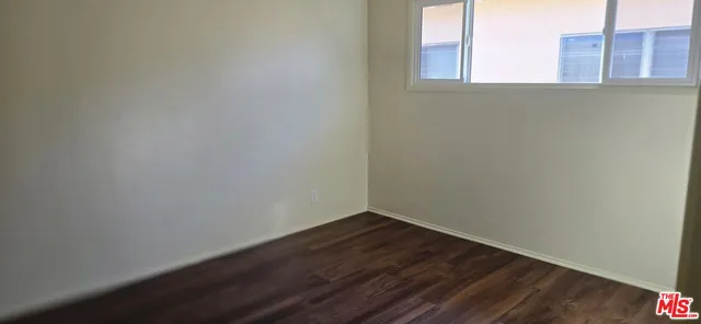 a view of a small space with wooden floor and a window