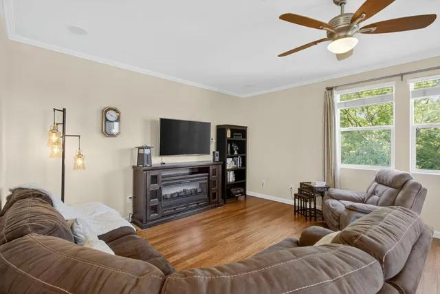 a living room with furniture ceiling fan and a window
