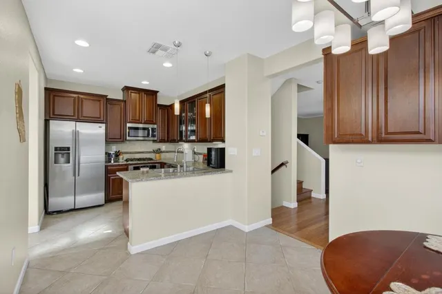 a kitchen with stainless steel appliances granite countertop a sink stove and microwave