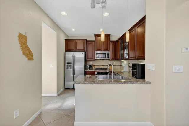 a kitchen with stainless steel appliances granite countertop a sink stove and microwave