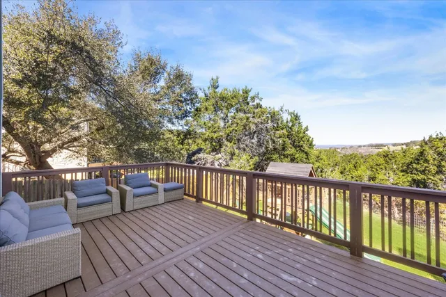 a balcony with wooden floor and outdoor seating