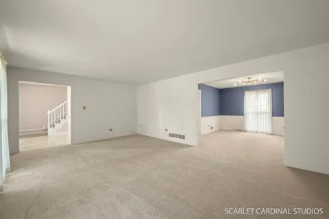 a view of an empty room with closet and a window