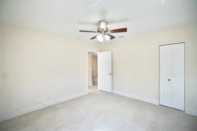 an empty room with a ceiling fan and a window