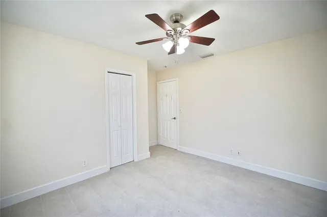 an empty room with a chandelier fan