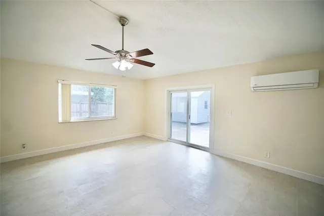 an empty room with a window and a ceiling fan
