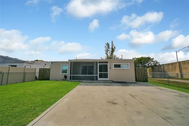 a view of a house with a yard and potted plants