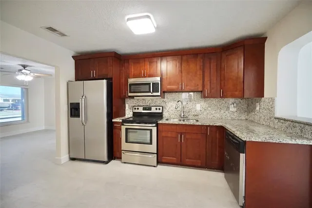a kitchen with granite countertop stainless steel appliances and refrigerator