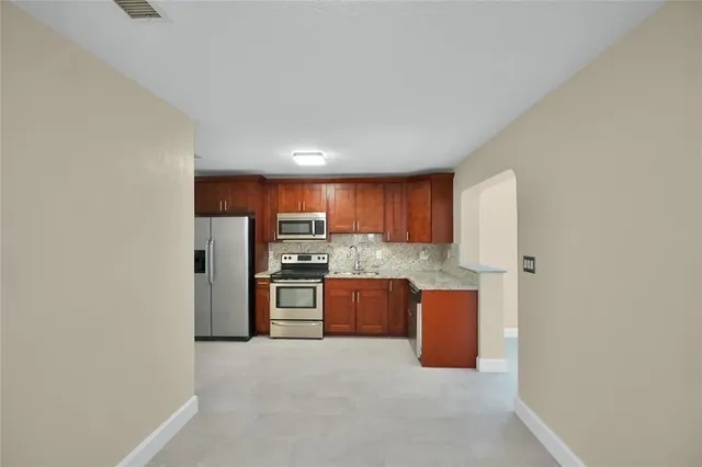 a kitchen with stainless steel appliances a refrigerator and a stove top oven