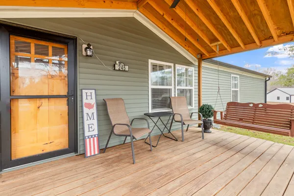 a balcony with wooden floor and a glass door