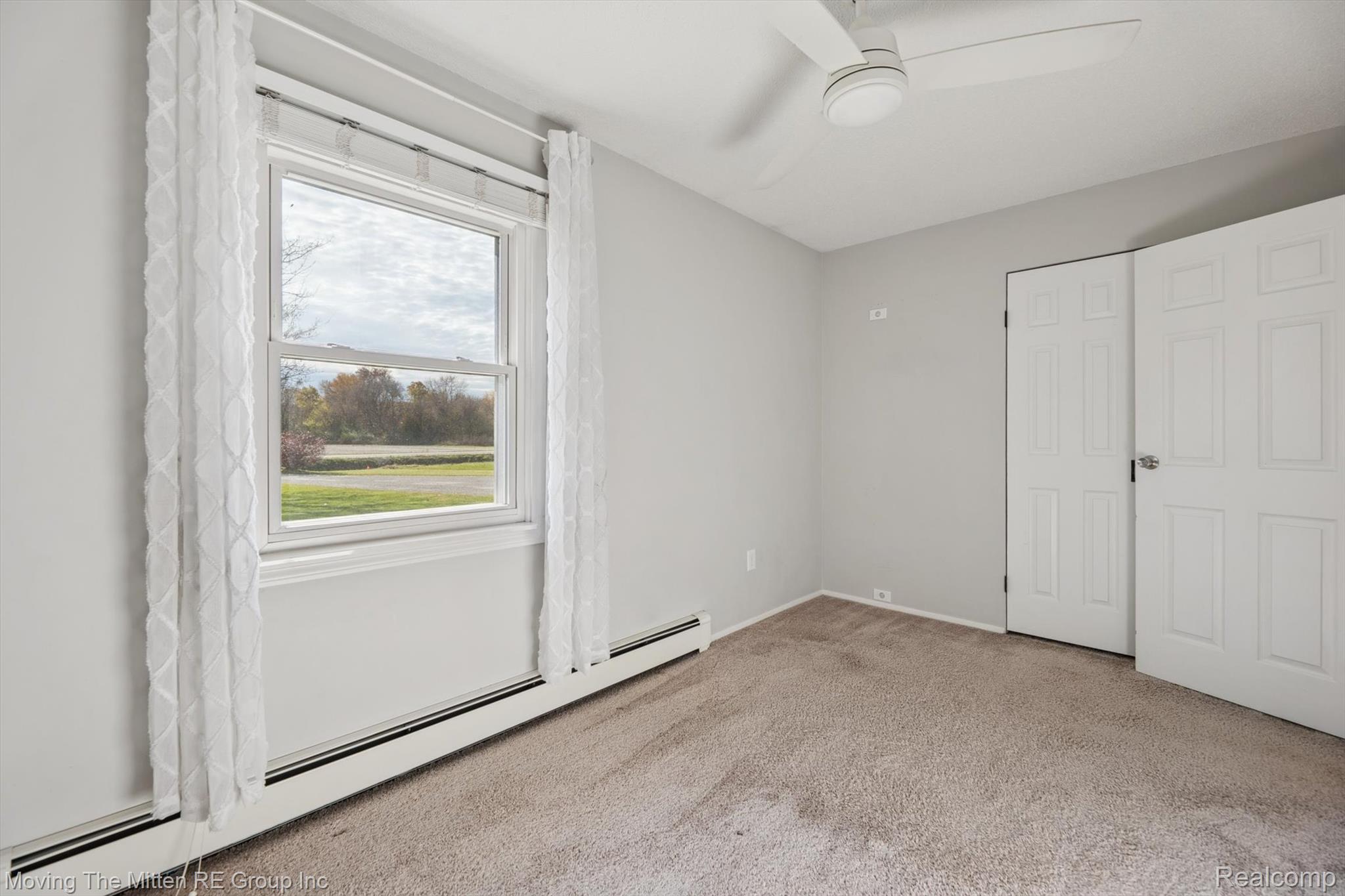 12000 Plank Road Milan, MI 48160 - Photo 22 of 49 Unfurnished bedroom with a baseboard heating unit, light carpet, and a ceiling fan