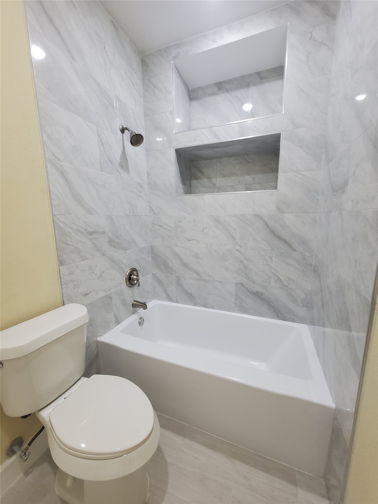 1306 North 9th Street Conroe, TX 77301 - Photo 19 of 47 a white toilet sitting next to a bathtub