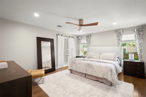 a spacious bedroom with a large bed and a chandelier