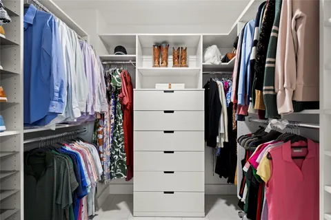 a view of walk in closet with clothes and shoes