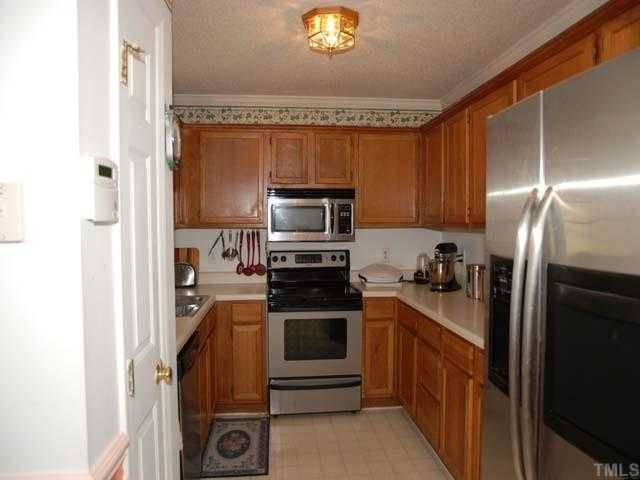 2316 Anihinga Court Raleigh, NC 27616 - Photo 2 of 4 a kitchen with a refrigerator stove and microwave