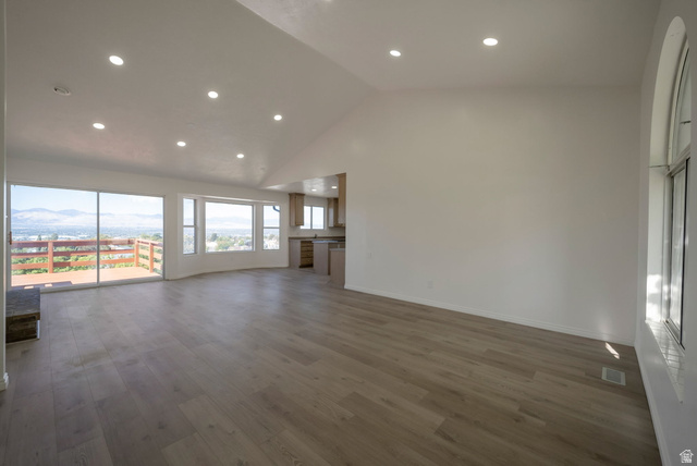 11922 Bluff View Drive Sandy, UT 84092 - Photo 5 of 30 Unfurnished living room featuring lofted ceiling, recessed lighting, dark wood-style floors, and a mountain view