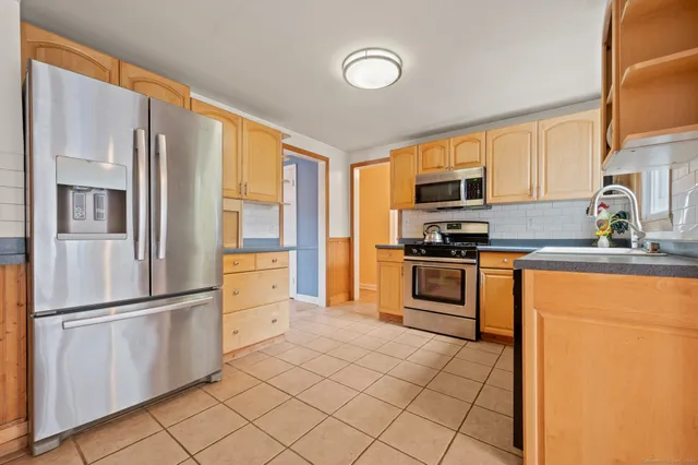 a kitchen with granite countertop a refrigerator stove and microwave