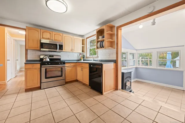 a kitchen with stainless steel appliances granite countertop a stove top oven a sink a counter top space and cabinets