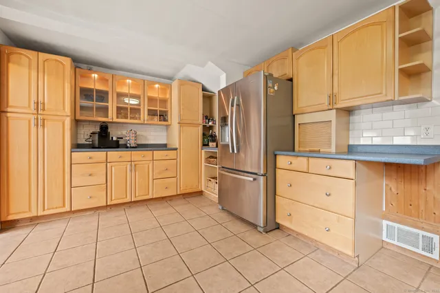 a kitchen with white cabinets a sink a window and stainless steel appliances