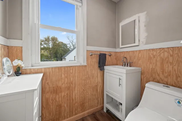 a bathroom with a sink toilet and window
