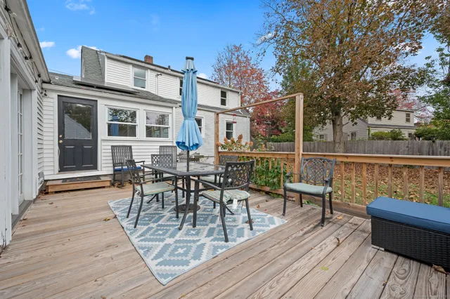 a view of a roof deck with table and chairs and wooden floor