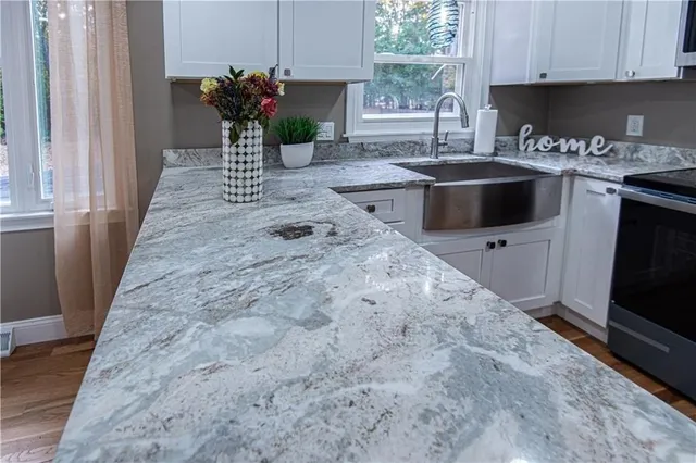 a kitchen with stainless steel appliances granite countertop a sink a stove and a microwave