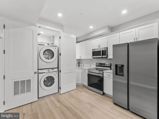 a kitchen with stainless steel appliances a refrigerator and a stove top oven