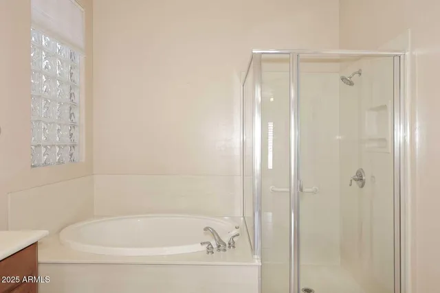 a white bath tub with shower and a sink