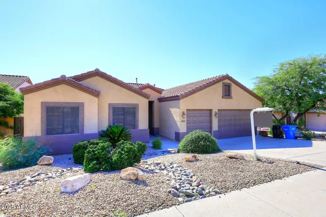 a view of a house with a yard and potted plants