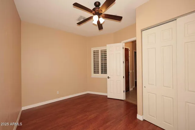 a view of a livingroom with a ceiling fan and wooden floor