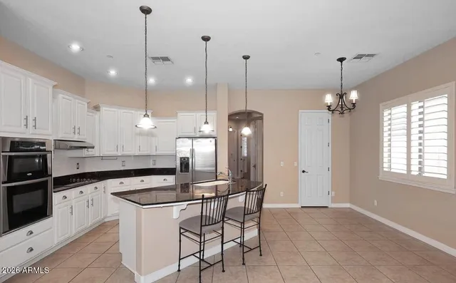 a kitchen with kitchen island granite countertop a sink a center island and stainless steel appliances
