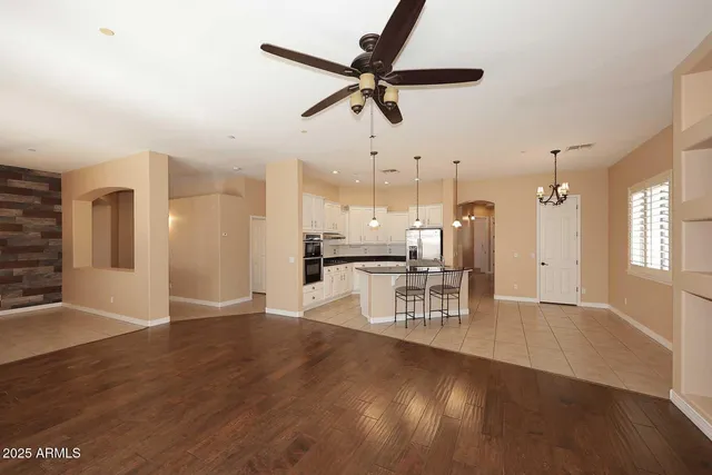 a view of a workspace with wooden floor and a ceiling fan
