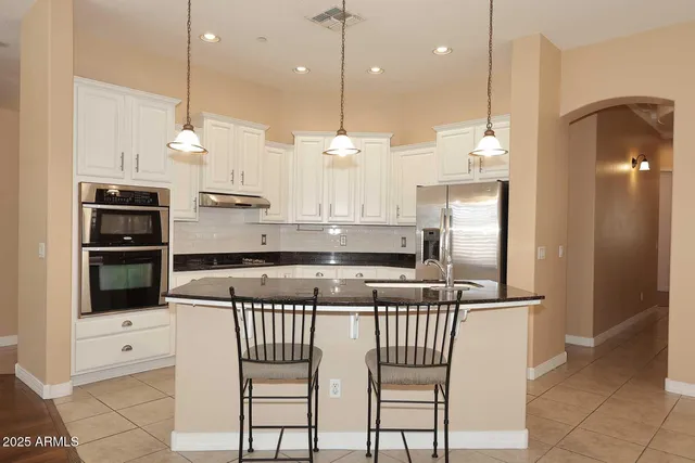 a kitchen with stainless steel appliances granite countertop a stove a sink and a refrigerator