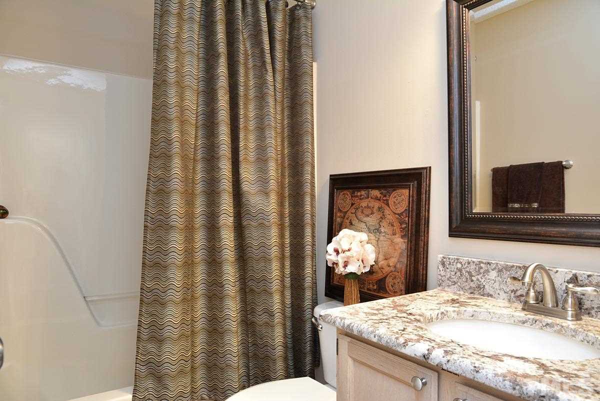 4517 Emmit Drive Raleigh, NC 27604 - Photo 17 of 25 a bathroom with a granite countertop sink and a mirror with toilet