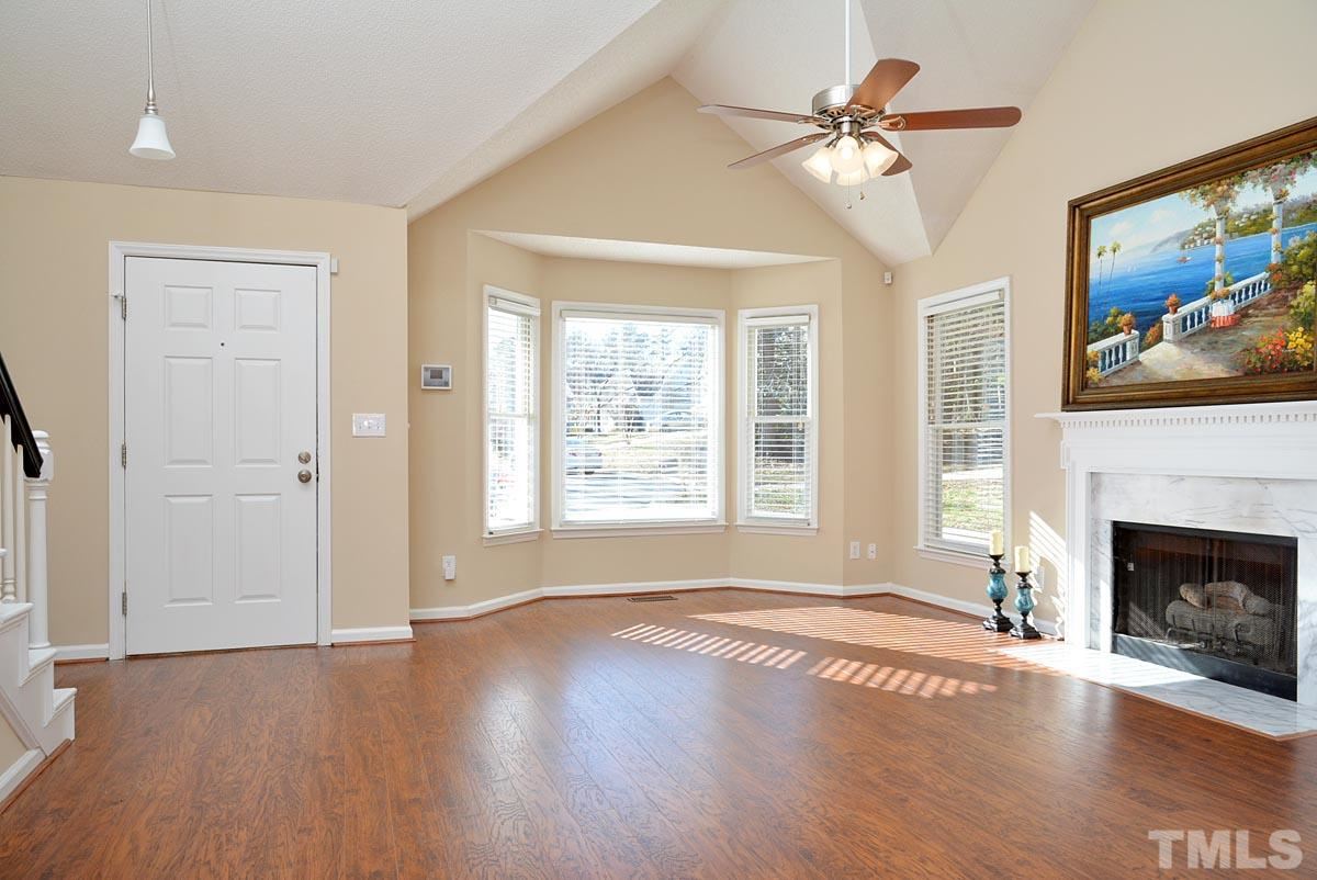 4517 Emmit Drive Raleigh, NC 27604 - Photo 3 of 25 an empty room with windows fireplace and a chandelier fan